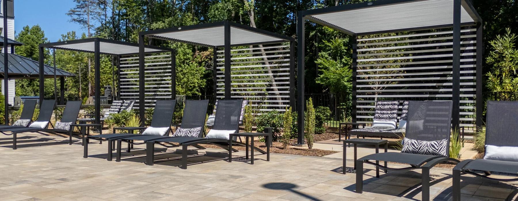 a patio with longe chairs and cabanas